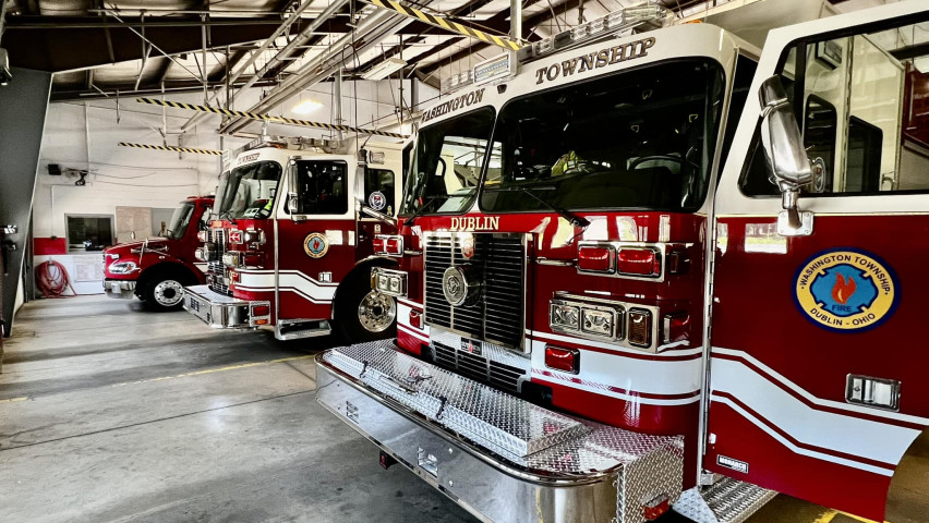 Inside photo of a firestation, showing firetrucks and ambulances 